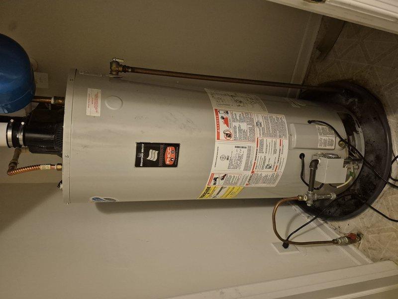 Conducted on-site evaluation of existing residential water heater system for replacement estimate. Unit appears to be original to the home and is a standard vertical tank-style water heater installed in an interior utility closet. Current installation includes proper safety components including blue expansion tank with copper piping connections, seismic restraint strapping, flexible supply lines, and appropriate electrical connections. Documented existing equipment configuration with photographs showing all visible components, plumbing connections, and installation conditions. System evaluation confirms need for replacement due to age. Provided comprehensive estimate for new water heater installation to maintain household hot water supply.