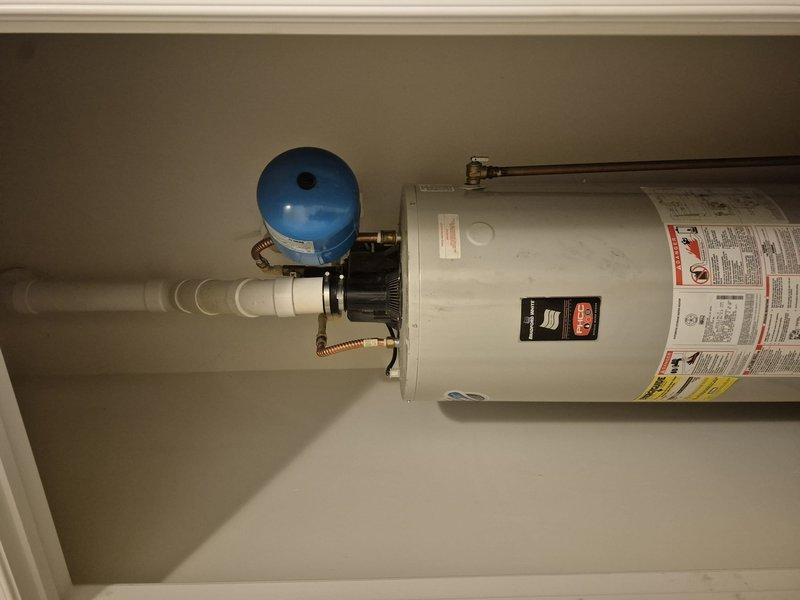 Conducted on-site evaluation of existing residential water heater system for replacement estimate. Unit appears to be original to the home and is a standard vertical tank-style water heater installed in an interior utility closet. Current installation includes proper safety components including blue expansion tank with copper piping connections, seismic restraint strapping, flexible supply lines, and appropriate electrical connections. Documented existing equipment configuration with photographs showing all visible components, plumbing connections, and installation conditions. System evaluation confirms need for replacement due to age. Provided comprehensive estimate for new water heater installation to maintain household hot water supply.