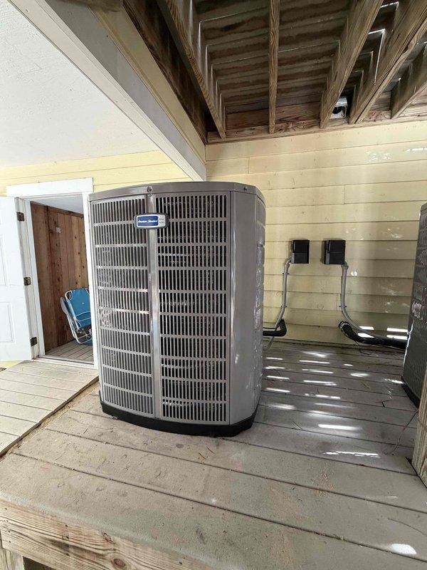 Completed full heat pump system installation by removing and disposing of old equipment, then installing one American Standard 5A6H4060A1000 4.5-ton 14 SEER single-stage heat pump with matching American Standard 5TXCD010AS3HC evaporator coil. Fabricated and installed metal duct transitions to adapt new equipment to existing ductwork, reused existing furnace and thermostat, replaced outdoor disconnect and electrical whip, reconnected existing condensation drain and power lines, and positioned outdoor unit on existing equipment stand under covered porch area.
