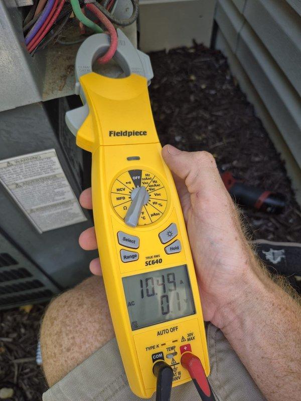 # HVAC Maintenance - Cooling System Service

Performed scheduled cooling maintenance visit on residential air conditioning system. Conducted electrical diagnostics using clamp meter, measuring current draw and capacitance readings on compressor circuit, with readings indicating 1039 microfarads and 0.1 amp draw at terminal connections. Inspected supply plenum and ductwork insulation in attic space, recording supply air temperature of 53.2°F at the register, confirming adequate cooling performance and proper system operation. All components tested within normal operating parameters, system left in proper working condition.