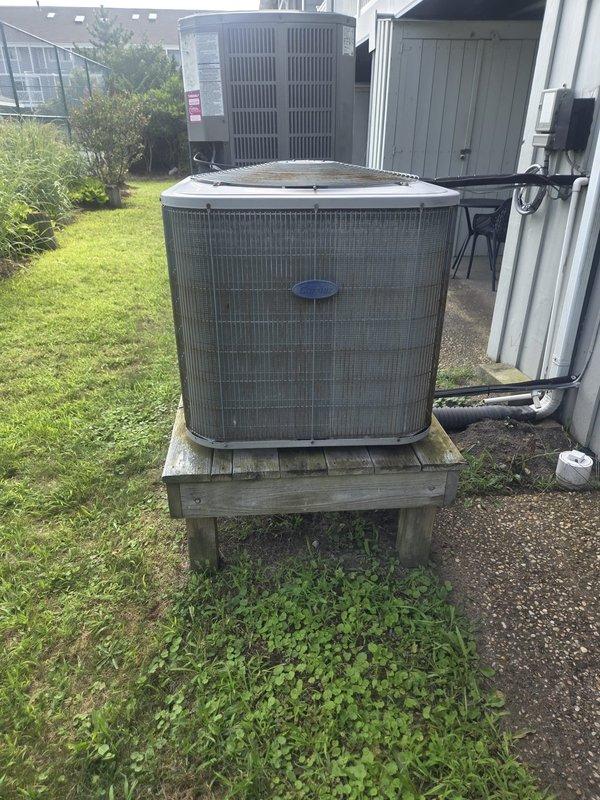 Completed preventative maintenance cooling inspection on two residential air conditioning systems. Performed comprehensive Cool Check service on both outdoor condenser units, including one cylindrical unit mounted on weathered wooden platform in backyard and one ComfortStart Platinum unit positioned on elevated wooden stand against exterior wall. Inspected electrical disconnects, refrigerant lines, condensate drainage, and verified proper operation of both cooling systems.