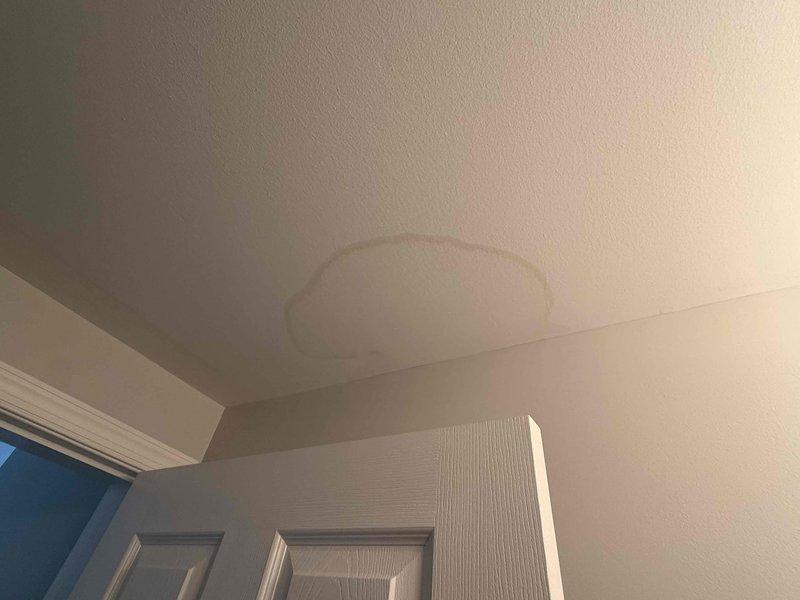 Responded to water leak complaint and performed visual inspection of affected areas. Identified water damage on ceiling surface near interior corner, with visible staining indicating active or recent moisture intrusion. Investigated potential sources including HVAC condensate drain system and water heater to determine origin of leak and recommend appropriate repairs.