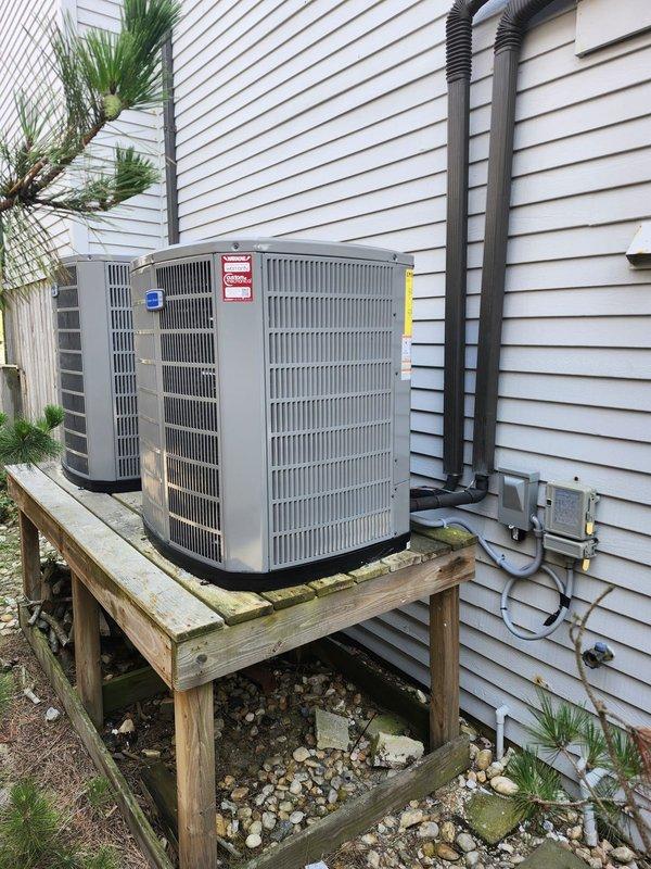 Completed full HVAC system replacement including removal and disposal of existing equipment. Installed 5A6H7048 4-ton 17 SEER heat pump outdoor unit on existing platform with new electrical whip and disconnect. Installed 5TEM6D06 variable speed fan coil unit indoors with BAYHTR1715BRKR 15KW electric heat strip and breaker. Flushed, pressure tested, and recharged refrigeration lines to manufacturer specifications. Installed 1-inch filter rack and THX1200W WiFi thermostat for system control. System startup and commissioning completed with all parameters verified within normal operating range. Diagnostic readings confirmed proper refrigerant charge, superheat, and subcooling values. Both outdoor units operational and mounted securely on wooden platform with proper electrical connections and conduit routing along exterior wall.