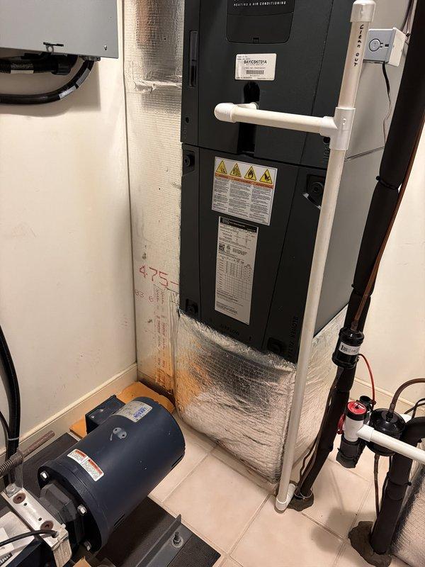 Performed scheduled cooling maintenance visit on residential HVAC system. Inspected air handler unit, water heater, and associated mechanical equipment in utility room. Documented current equipment conditions including American Standard water heater with reflective insulation, electrical panel connections, PVC drainage lines, refrigerant piping with service valves, and circulation pump components. All equipment photographed for service records and system operational status verified.