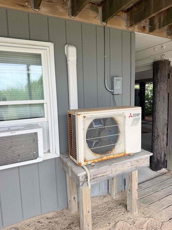 Completed diagnostic evaluation on a 2020 Mitsubishi MUZ-FH09NA mini-split outdoor unit experiencing operational failure due to faulty PCB board. Determined replacement of control board and installation of surge protector required to restore system functionality. Documented exterior unit condition including rust staining on condensing unit casing and refrigerant lines, and noted potential future relocation of outdoor unit per owner preference. Parts ordered with estimated two-week lead time for repair completion.
