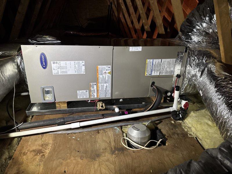 Completed full HVAC system replacement including removal and disposal of existing equipment. Installed Carrier 27SCA524A003 2-ton 15 SEER heat pump outdoor unit on existing platform with new outdoor disconnect and electrical whip. Installed Carrier FJ5ANXB24L00 air handling unit in attic space with 10kw electric heat kit, mounted on wooden platform between roof rafters. Fabricated and installed metal duct transitions to adapt new equipment to existing ductwork. Reused existing electrical connections, condensate lines, and power supply lines where applicable. Installed Honeywell S1200 thermostat for system control. Verified proper system operation including temperature differential measurements across air handler and ductwork. System includes one-year parts and labor warranty covering both installed units.