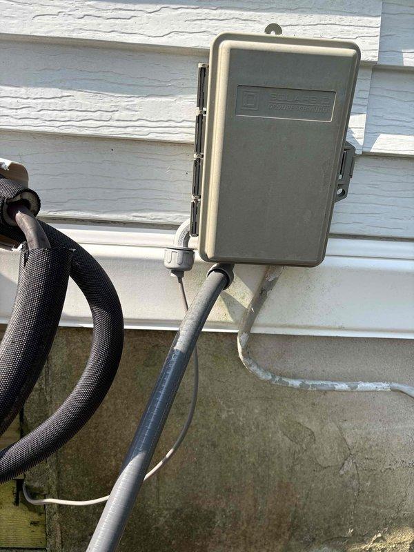 Responded to service call for second ductless mini split system not operating after initial visit for separate unit. Inspected outdoor disconnect box and electrical connections at condenser unit. Verified breaker was not tripped at main panel. Examined wiring terminations, contactor, and terminal block connections inside disconnect enclosure. Documented existing electrical configuration with photos showing wire connections, orange wire nuts, and conduit entries for diagnostic purposes and future reference.
