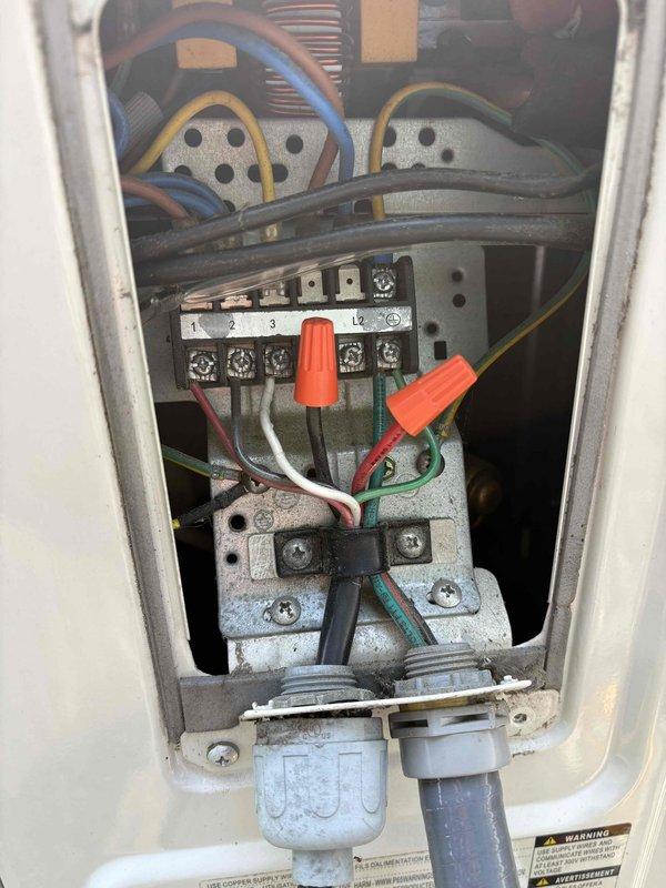 Responded to service call for second ductless mini split system not operating after initial visit for separate unit. Inspected outdoor disconnect box and electrical connections at condenser unit. Verified breaker was not tripped at main panel. Examined wiring terminations, contactor, and terminal block connections inside disconnect enclosure. Documented existing electrical configuration with photos showing wire connections, orange wire nuts, and conduit entries for diagnostic purposes and future reference.