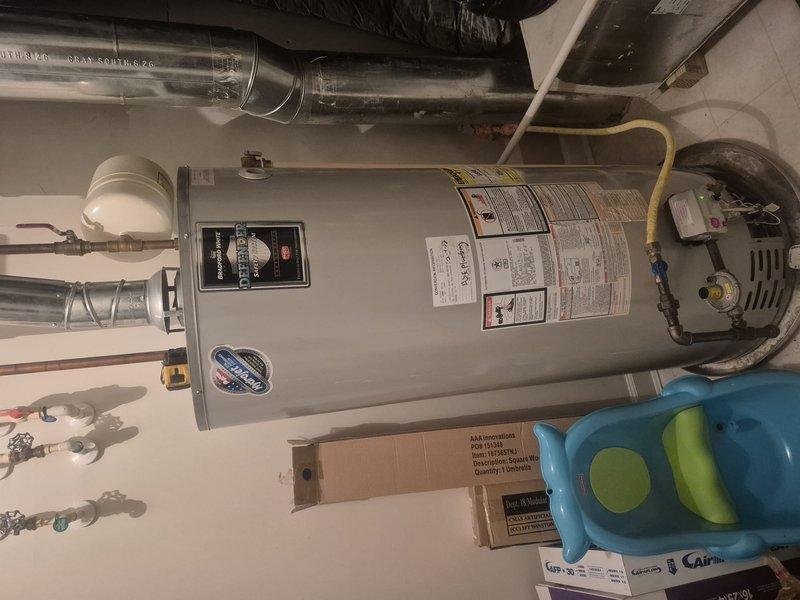 Conducted on-site evaluation of existing residential water heater system located in utility room. Inspected current gray cylindrical water heater unit, documented manufacturer specifications, control panel functionality, and overall condition of installation. Assessed plumbing connections including copper supply lines, PVC drainage system, flexible hoses, and shut-off valve configuration. Evaluated HVAC ductwork proximity and clearance requirements. Provided comprehensive estimate for water heater replacement including removal of existing unit and installation of new system with proper code-compliant connections.