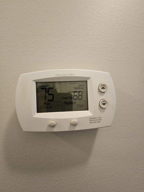 Completed comprehensive tune-up inspection on residential cooling system with dual outdoor condenser units located near elevated deck area. Verified thermostat operation showing system actively cooling with 75°F ambient temperature and 68°F setpoint, confirmed proper communication between Honeywell digital control and equipment. Inspected outdoor units positioned on mulched ground, assessed overall system condition, and advised customer of findings with repair recommendations exceeding standard maintenance scope.
