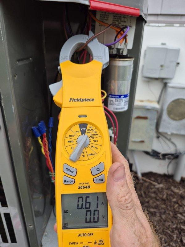 Performed preventive maintenance cooling visit on residential HVAC system. Tested electrical components using clamp meter, verified capacitor operation and electrical connections within condensing unit panel. System operating properly with thermostat set to cooling mode at 76°F, circulating fan active, and unit cycling normally.