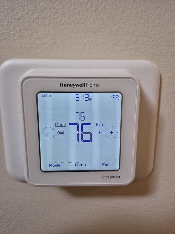 Performed preventive maintenance cooling visit on residential HVAC system. Tested electrical components using clamp meter, verified capacitor operation and electrical connections within condensing unit panel. System operating properly with thermostat set to cooling mode at 76°F, circulating fan active, and unit cycling normally.