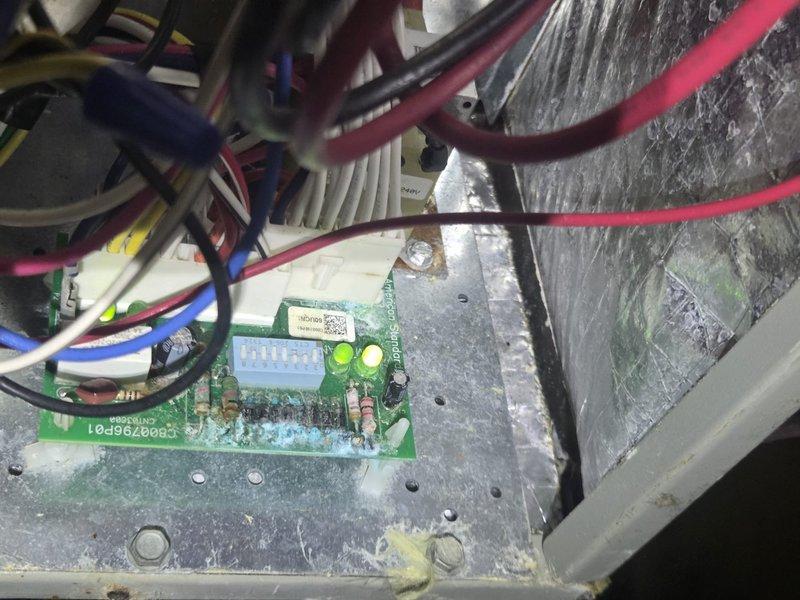 Responded to no cooling complaint on system less than 10 years old. Upon arrival, performed diagnostic testing using electronic measurement equipment to assess system performance and identified control board issue with LED indicators illuminated. Inspected internal wiring connections, terminal blocks, and circuit board assembly within air handling unit, finding dust accumulation and verifying proper electrical connections across multiple wire circuits.