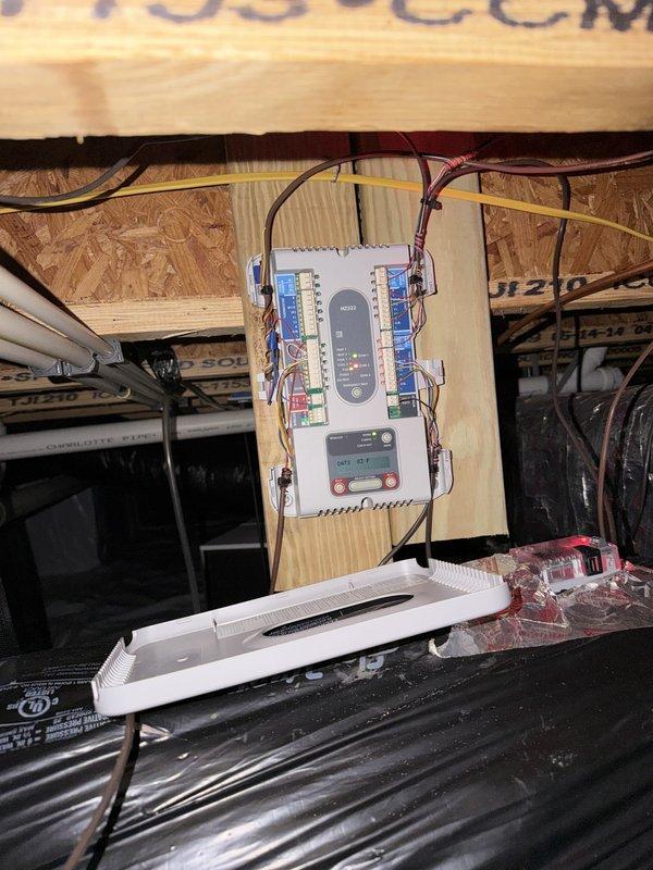 Conducted on-site assessment of existing HVAC system for replacement estimate. Evaluated Comfortmaker outdoor condensing unit installed on concrete pad with visible wear and aging components. Inspected attic-mounted air handler and associated electrical controls, including zone control panel with multiple terminal connections and digital display module. Documented current system configuration, wiring runs, and equipment placement. Photographed existing equipment conditions to support replacement proposal specifications.