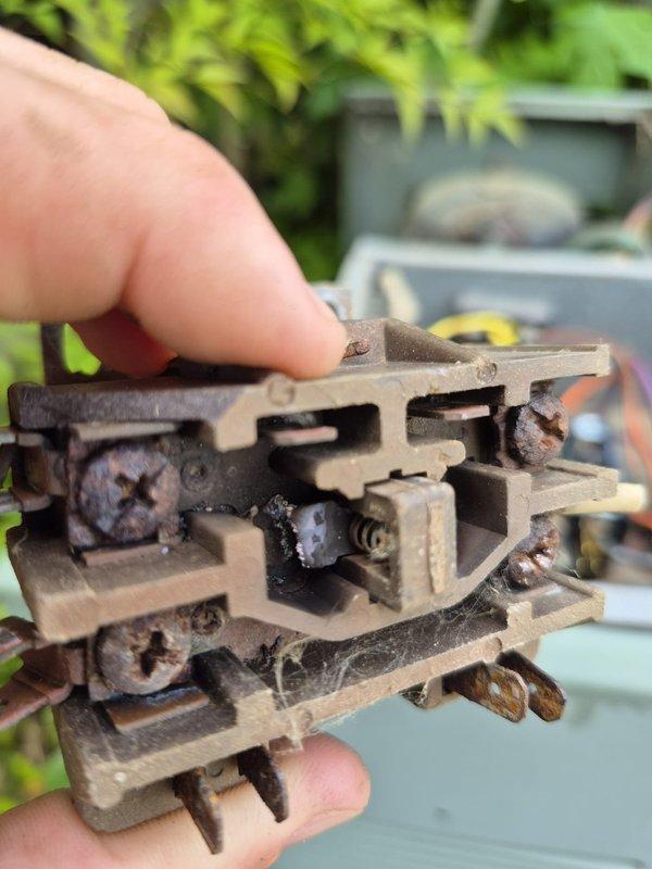 Responded to no cooling complaint on residential HVAC system. Upon inspection, discovered heavily corroded contactor with significant rust and deterioration on metal contact points, insulating blocks, and mounting hardware. Contactor showed extensive oxidation and environmental damage from prolonged outdoor exposure, preventing proper electrical contact closure. Removed failed contactor, installed new replacement unit, and restored cooling operation to system.