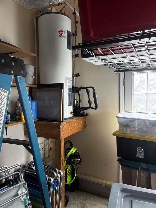 Completed routine cooling maintenance visit. Inspected and documented water heater installation in utility room, verifying proper mounting, clearances, and platform dimensions for service accessibility. Unit found in satisfactory operating condition with all safety labels visible and plumbing connections secure.