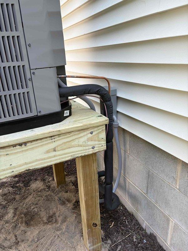 # Complete HVAC System Replacement

Removed and properly disposed of existing HVAC equipment from the property. Installed new outdoor condensing unit on a custom-built pressure-treated wood platform at ground level, ensuring proper elevation and drainage. Mounted new fan coil unit indoors with drain pan and integrated shut-off valve for maintenance accessibility.

Installed electrical whip and disconnect switch to meet code requirements for the outdoor unit. Flushed existing refrigeration lines to remove contaminants, performed pressure testing to verify system integrity, and recharged the system with appropriate refrigerant to manufacturer specifications. All refrigerant lines were properly insulated with foam pipe insulation and secured along the building exterior.

Installed and programmed Honeywell WiFi thermostat, providing remote temperature control and system monitoring capabilities. Verified all electrical connections, tested system operation in both heating and cooling modes, 