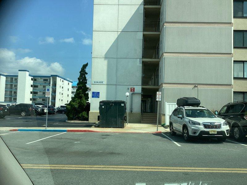 Conducted on-site evaluation for mini split installation at multi-story residential building with textured stucco exterior and corrugated metal siding. Assessed exterior wall conditions, structural mounting requirements, and optimal placement for outdoor condenser unit near building corner with consideration for existing ventilation openings and architectural features.