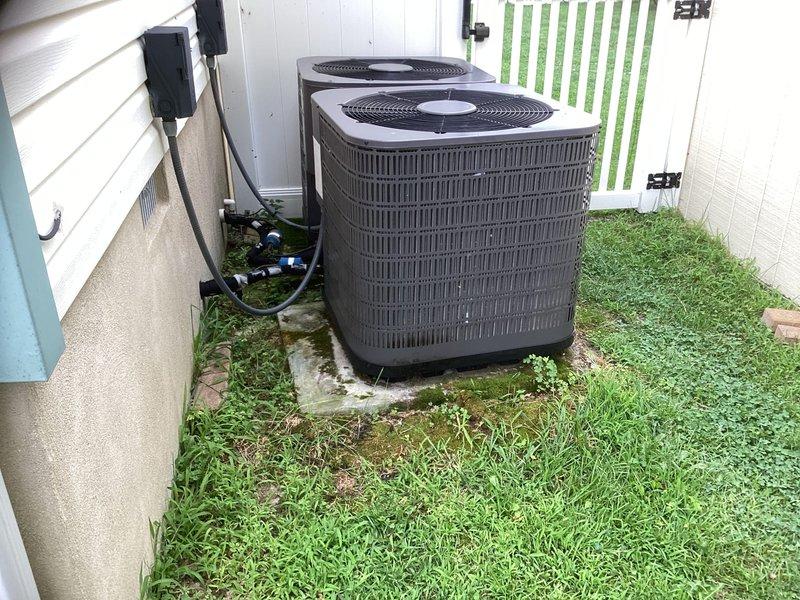 Provided estimate for complete replacement of downstairs HVAC system located in crawl space. Assessed existing chain-mounted air handler unit with refrigerant lines and ductwork, along with dual outdoor condenser units positioned on concrete pad in side yard, and documented current equipment configuration and installation requirements for system replacement.