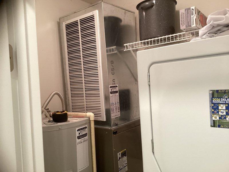 Conducted comprehensive site assessment for complete HVAC system and water heater replacement. Evaluated existing Carrier outdoor condenser unit and indoor furnace system, documented current equipment specifications and installation conditions. Photographed equipment layout including outdoor unit placement on pad with mulch base and indoor furnace/water heater configuration in utility closet. Gathered necessary information and completed estimate form for simultaneous replacement of heating, cooling, and water heating systems.