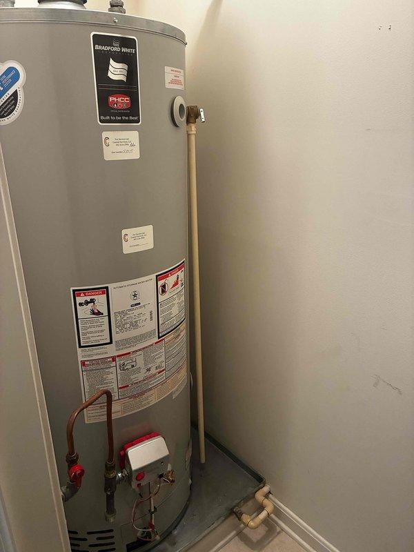 Responded to service call for Bradford White water heater overheating issue following previous contractor's diagnosis of faulty thermostat. Performed diagnostic inspection of unit, documented existing installation conditions including 30-inch doorway clearance to utility room, and evaluated water heater components including upper thermostat, temperature and pressure relief valve, and gas control assembly. Assessed repair feasibility versus replacement options for customer consideration.