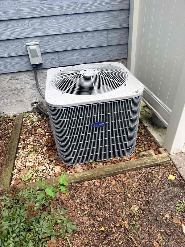 Completed full HVAC system replacement for 15-year-old unit with leaking coil. Installed new Carrier heating unit and air handler in garage/utility area with proper PVC condensate drainage and foil-wrapped ductwork connections. Installed new outdoor condenser unit on gravel pad with wooden frame containment, connected to exterior electrical service, and verified all refrigerant lines and system operations.