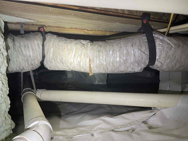 Responded to service call for disconnected and damaged flexible ductwork in crawl space initially identified by plumber. Upon inspection, found section of flex duct detached from supply vent with torn and shredded insulation jacket. Reattached ductwork to register boot, secured connections with appropriate fasteners and mastic sealant, and replaced damaged insulation sections to restore proper airflow and thermal efficiency to affected zone.
