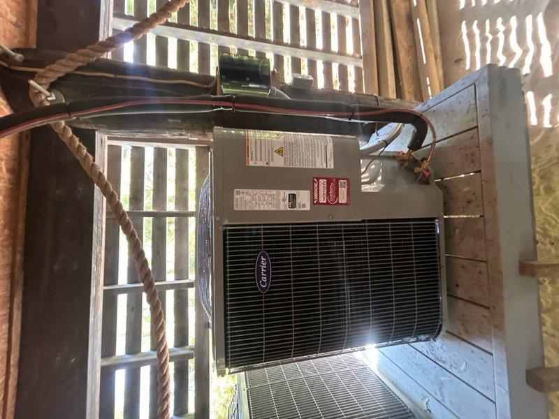 Completed full HVAC system replacement in upstairs attic space. Removed and disposed of existing equipment. Installed new Carrier 27SCA524A003 2-ton 15 SEER heat pump outdoor unit on existing stand with new outdoor disconnect and electrical whip. Installed Carrier FT5ANXB24L00 air handler in attic with Carrier 10 kW electric heat pack. Fabricated and installed metal duct transitions to adapt new equipment to existing ductwork. Reused existing electrical connections, condensate drain lines, and power supply lines where applicable. Installed Honeywell N100 digital thermostat for system control. Connected refrigerant lines between outdoor heat pump and indoor air handler. Verified proper condensate drainage with PVC drain line installation. Tested all electrical connections and system operation. Confirmed proper airflow through ductwork and adequate system performance. Equipment positioned on white platform support structure in attic space with filter access at unit. All installations mee