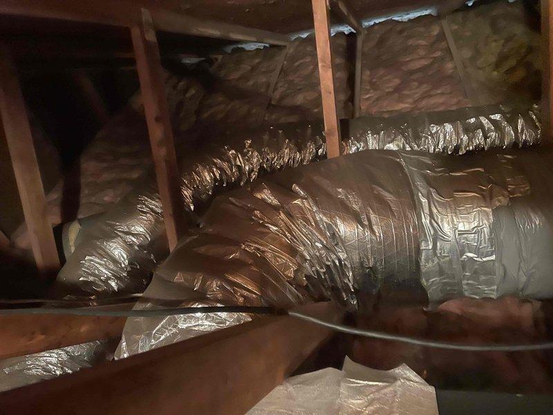 Responded to no cooling call on residential HVAC system less than 10 years old. Upon arrival, performed diagnostic evaluation of attic-mounted air handler and associated ductwork system. Inspected unit operation, verified proper airflow through flexible duct runs, and checked electrical connections at equipment and attic ventilation fan. System evaluated and customer advised of findings requiring repair work exceeding minimum service threshold. Documentation completed with photographic records of attic installation, including air handler placement, flex duct routing, and overall system configuration.