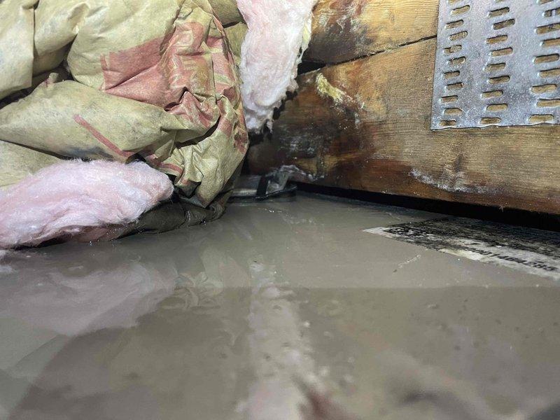 Responded to no cooling call and found system inoperative. Upon inspection, discovered severe water intrusion in crawl space affecting HVAC equipment area with standing water, extensively damaged and saturated insulation, and significant water damage to structural components. Documented conditions with photos showing compromised wooden beams with dark staining indicative of prolonged moisture exposure and deteriorated fiberglass insulation throughout the space. System unable to operate safely due to water damage in equipment vicinity. Advised customer of moisture intrusion issues requiring immediate remediation before HVAC repairs can proceed safely.