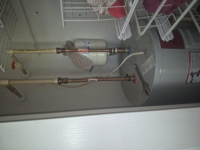 Responded to service call for small water leak near water heater. Upon inspection, identified leak at water pipe connection point. Repaired the leaking water pipe connection at the tanked water heater installation. Verified proper operation of State Industries electric storage tank water heater (Model ES6040085) with existing expansion tank and flexible copper corrugated supply lines. Tested all connections for leaks and confirmed system integrity upon completion.