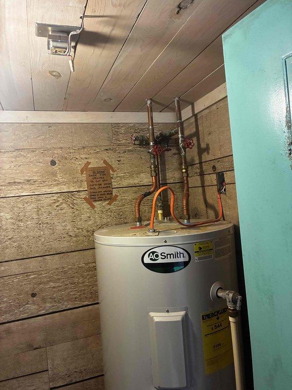 Responded to no hot water complaint on A.O. Smith tanked water heater. Upon arrival, performed electrical diagnostics using clamp meter to measure current draw on heating element circuit, obtaining reading of 18.28 amps. Inspected water heater installation including copper supply lines, temperature and pressure relief valve connections, and proper venting. Verified unit specifications and reviewed energy guide information. Diagnosed heating element failure preventing water from reaching set temperature. Documented equipment condition and measurements for repair recommendation.