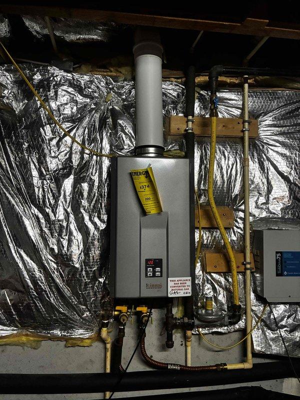 Completed scheduled maintenance inspection on second of two tankless water heater units located in attic space. Performed comprehensive system check including examination of gas connections, water supply lines, exhaust venting, and control panel operation. Verified proper function of all components, confirmed secure mounting, and ensured all connections remain leak-free and properly insulated.