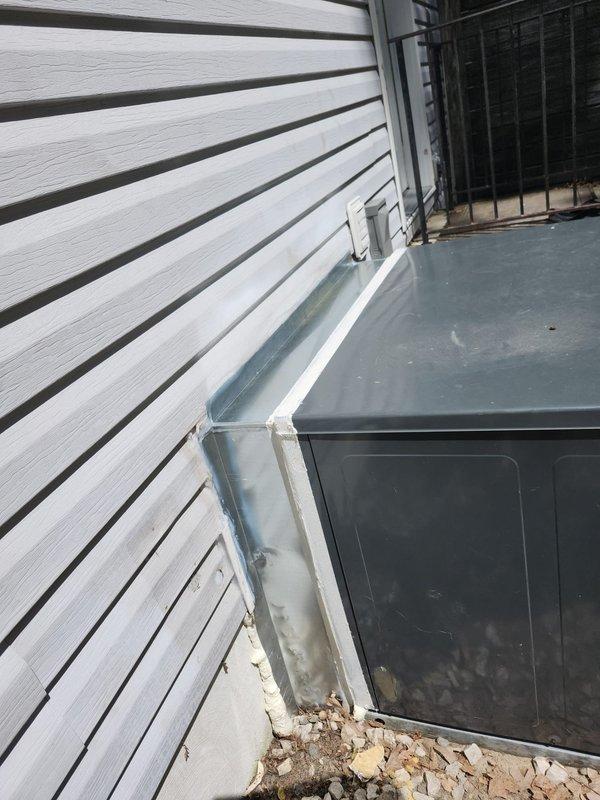 Removed existing gas pack unit and installed metal transitions and sleeves to connect to existing ductwork in crawlspace. Reconnected all electrical wiring and refrigerant piping to new package unit. Installed metal duct shroud between package unit and building exterior to enclose new ductwork and crawlspace opening, then sealed all new duct connections with hardcast tape to ensure proper air sealing and system efficiency.