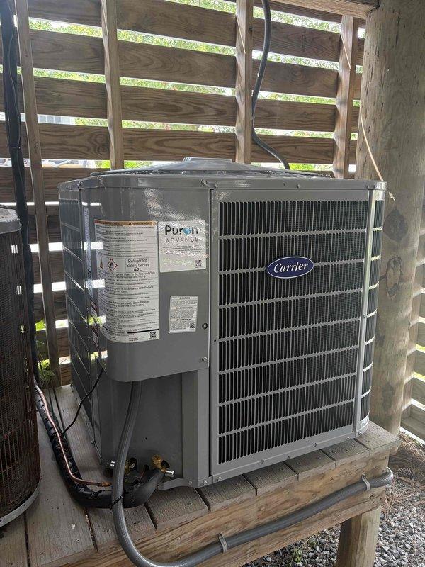 Removed and disposed of existing first floor HVAC system. Installed Carrier 27TPA824 2-ton 17 SEER heat pump condenser unit on existing outdoor stand with proper gravel base and deck clearance. Installed FT5ANXB024 variable speed fan coil unit with integrated 10KW electric heat strip and circuit breaker. Ran new electrical whip and installed disconnect box for outdoor unit. Flushed existing refrigerant lines, performed pressure test to verify system integrity, and recharged system to manufacturer specifications. Installed THX1200W WiFi-enabled programmable thermostat for system control. Verified all electrical connections, refrigerant charge, and airflow parameters. Conducted second floor system inspection to document equipment model and serial numbers for addition to maintenance agreement. System tested and operational upon completion.