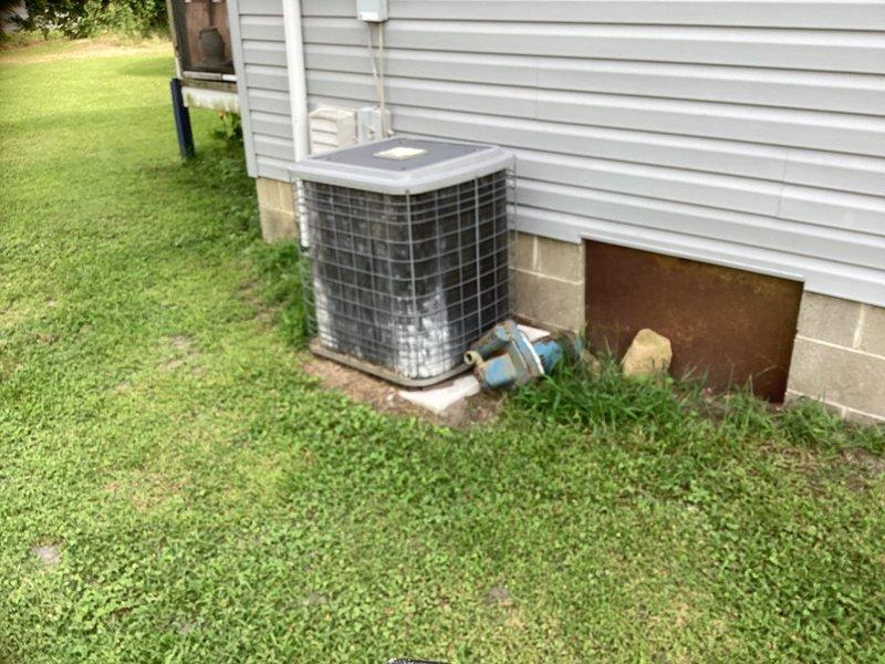 Conducted on-site evaluation for complete HVAC system replacement of existing air conditioning unit and oil-fired heating system. Assessed current equipment condition, documented existing outdoor condensing unit on concrete pad with PVC refrigerant lines, and inspected indoor furnace installation located in utility area. Provided comprehensive replacement estimate for new heating and cooling system to modernize customer's climate control equipment.