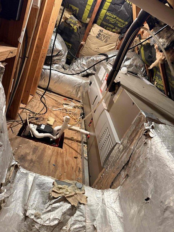 Conducted comprehensive assessment of existing HVAC system for full replacement estimate. Evaluated outdoor Luxaire condensing unit showing age-related wear and weathering on concrete pad with algae growth, along with indoor attic-mounted air handler and associated ductwork. Documented current system configuration including flexible duct routing, electrical connections, and refrigerant lines to provide accurate replacement specifications for main heating and cooling system.