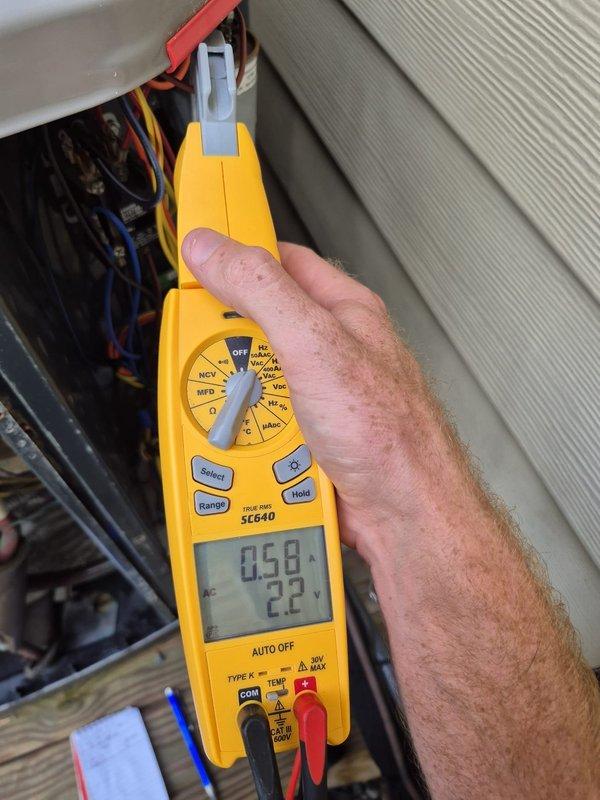 Performed scheduled heating maintenance visit on HVAC system. Conducted electrical diagnostics using multimeter to verify voltage readings and system amperage at the outdoor unit's electrical panel, measuring 22V and 0.58A with all readings within normal operating parameters. Inspected internal components and wiring connections, confirming all electrical connections were secure and system was operating properly for the heating season.