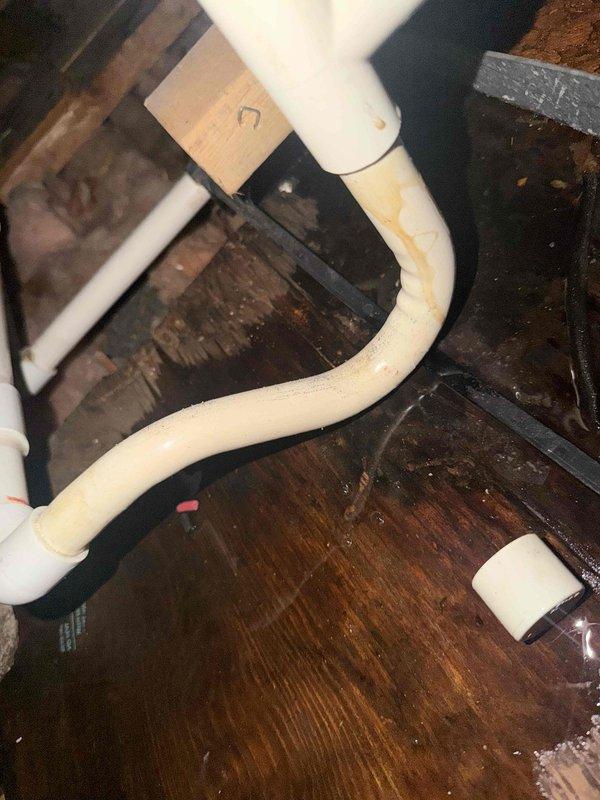 Responded to no cooling complaint and performed system evaluation. Upon inspection, found unit semi-operational with deteriorated drain pan requiring replacement due to rot damage. Verified condensate drainage system functionality and documented existing PVC drain line configuration with support brackets in crawl space area. System check completed and estimate provided for drain pan replacement to prevent future water damage and maintain proper condensation removal.