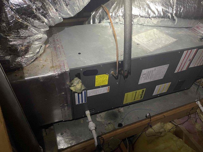 Responded to no cooling complaint on residential split system. Upon arrival, performed diagnostic evaluation of indoor air handler unit located in attic space and outdoor condensing unit. Inspected refrigerant lines, electrical connections, and condensate drainage system. Verified proper installation and mounting of equipment. System components appeared intact with normal wear for age. Completed visual inspection of both indoor and outdoor units, documented equipment condition with photographs for service records. Unit operational status assessed and findings communicated for resolution of cooling issue.