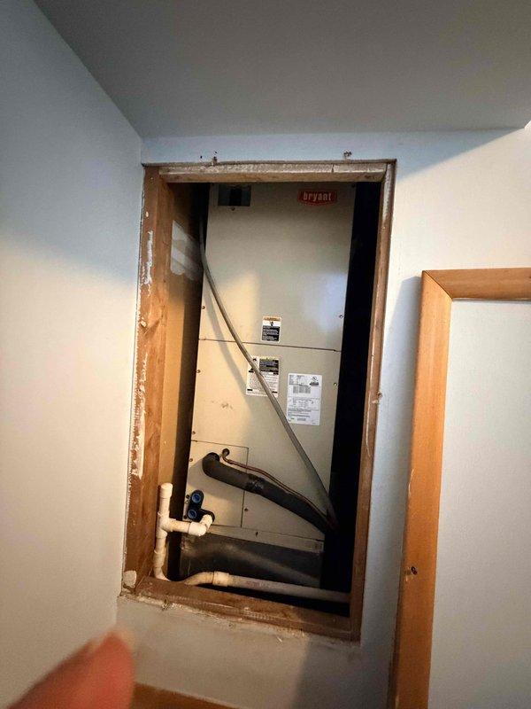 Conducted on-site evaluation for HVAC system replacement at residential condo unit. Assessed existing Bryant indoor air handler installed in interior wall cavity with exposed framing and documented current equipment specifications. Evaluated outdoor condensing units positioned on exterior grade, noting two units present at property. Provided estimate for replacement system comparable to neighboring unit's installation, recommending 2.5-ton 14 SEER heat pump system to match identical condo layout and heating/cooling requirements.