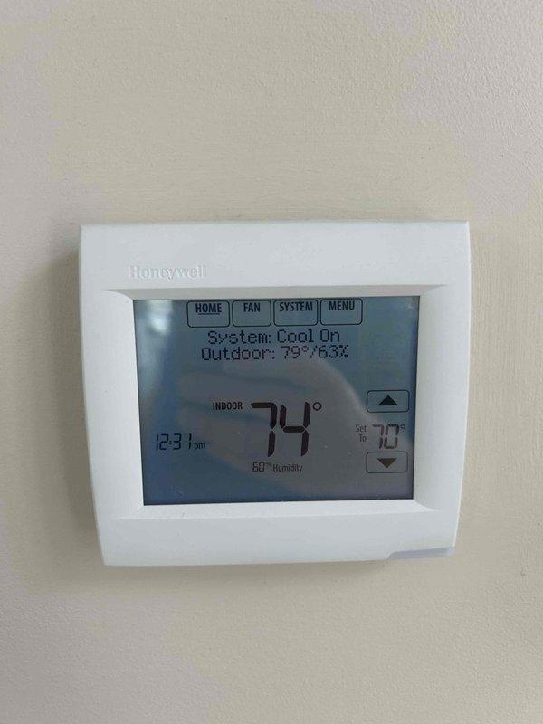 Responded to emergency no-cool call on 9-year-old residential HVAC system. Upon arrival, found thermostat calling for cooling with system running but inadequate temperature drop. Inspected attic-mounted air handler unit and verified proper airflow through supply ductwork. Checked refrigerant lines and connections at air handler, confirmed no visible leaks or damage to copper linesets or insulation. System restored to proper cooling operation with indoor temperature achieving setpoint of 74 degrees as displayed on Honeywell digital thermostat.