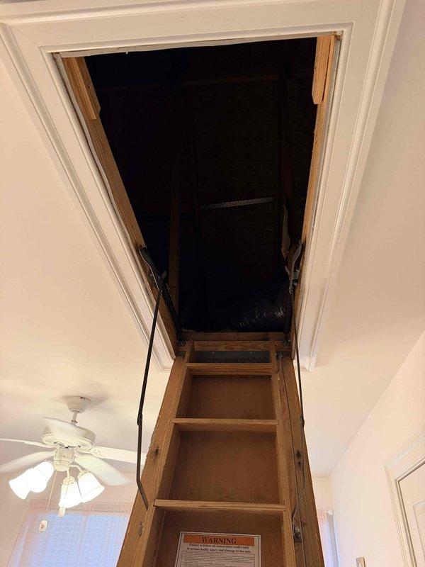 Assessed 14-year-old HVAC system serving loft area that was reported out of refrigerant. Inspected attic-mounted air handler unit, deteriorated flexible ductwork, and associated components via pull-down attic access. Documented equipment condition and provided replacement system estimate due to age of unit and refrigerant loss.
