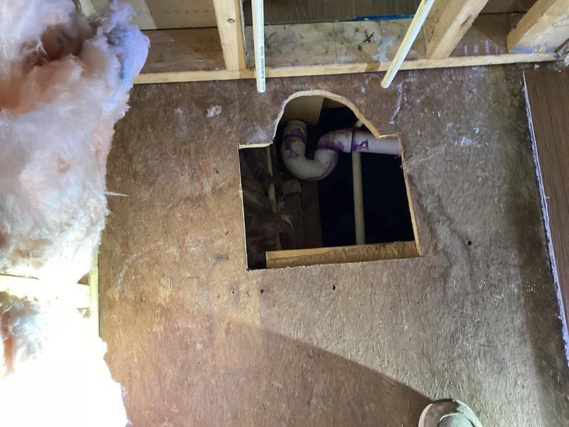 Completed plumbing rough-in for shower/tub installation in residential bathroom renovation. Installed drain assembly through subfloor with proper PVC piping, ensuring correct slope and secure connections for drainage system. Work performed in coordination with ongoing framing and insulation phases of bathroom remodel.