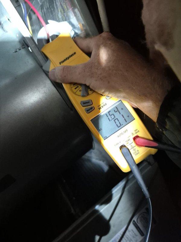 Completed scheduled heating maintenance visit on residential HVAC system. Performed electrical diagnostics using digital multimeter and clamp meter, measuring voltage readings of 15.4V and 23.1V at indoor unit, and current draw of 0.89A at outdoor unit electrical panel. Inspected capacitor, wiring connections, and control components; all measurements within normal operating parameters and system functioning properly.