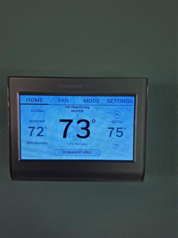 Completed heating system maintenance and diagnostic testing. Verified thermostat operation showing proper display function with indoor temperature at 73°F and setpoint at 75°F. Performed combustion analysis using diagnostic equipment, recording CO2 levels at 8.1%, stack temperature at 93°F, ambient air temperature at 78.9°F, excess air at 64.3%, and carbon monoxide at 7 ppm, confirming safe and efficient operation within acceptable parameters.