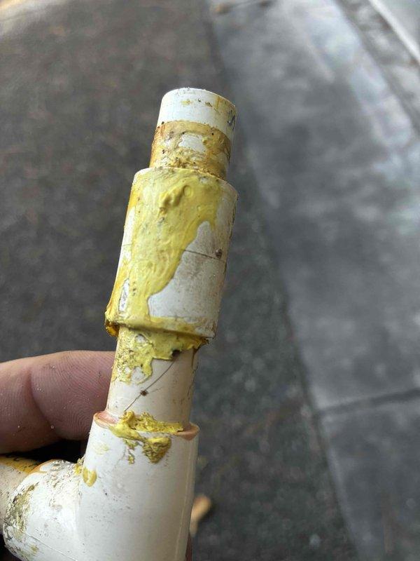 Responded to report of leak in crawl space beneath half bathroom, initially identified by pest control contractor. Upon inspection, discovered failed PVC drain pipe with significant deterioration and yellow discoloration indicating long-term sewage leakage from toilet waste line. Removed damaged pipe section showing crusty buildup and chemical degradation. Replaced compromised PVC coupling and affected pipe segment with new materials per code specifications. Verified proper slope and secure connections throughout drain assembly. Tested system for leaks and confirmed proper drainage function. Homeowner had previously shut off toilet supply valve as temporary measure prior to repair.