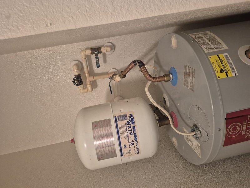 Conducted on-site evaluation of non-operational residential water heater located in first-floor utility closet. Upon arrival, shut off water supply and partially drained the existing unit to assess condition and prepare for replacement estimate. Inspected current installation including water heater tank, associated copper and PVC plumbing connections, shut-off valves, flexible connector lines, and water treatment system. Documented existing configuration with photographs for replacement planning and proper sizing recommendations.