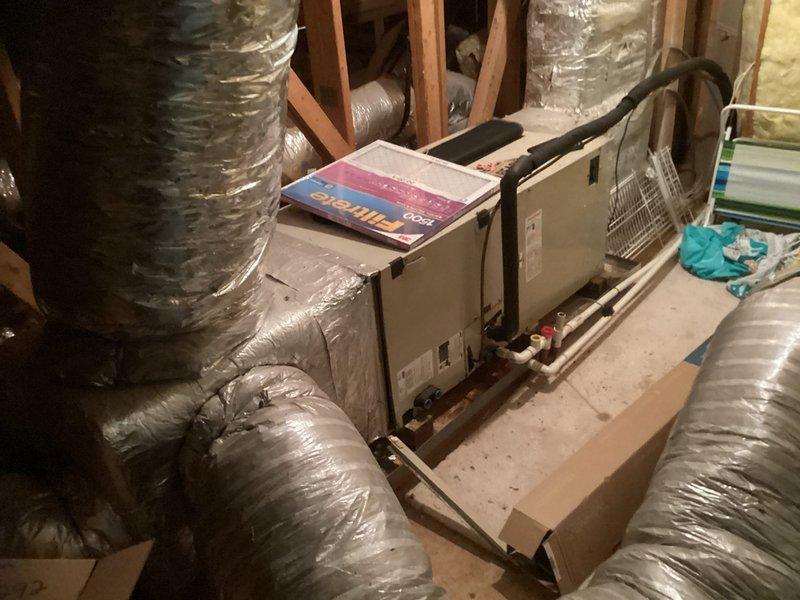 Responded to emergency service call for non-cooling AC system with depleted R22 refrigerant. Conducted on-site assessment and obtained measurements for complete HVAC system replacement in residential property. Documented existing horizontal air handler installation in basement mechanical space with flexible ductwork configuration and photographed equipment specifications to prepare replacement estimate for obsolete R22 system.