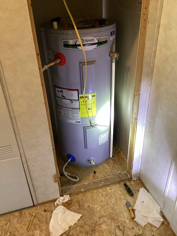 Responded to service call to reattach A.O. Smith Q150 water heater that had become disconnected from its mounting system. Upon arrival, accessed the mechanical closet and secured the water heater unit back into proper position within the wooden-framed alcove. Verified all plumbing connections including copper water supply lines with shutoff valves, yellow flexible gas line, and bottom discharge piping remained intact and properly sealed. Confirmed electrical connection at breaker panel remained secure with no tripped breakers. Tested unit operation and verified no leaks at connections. Left water heater fully operational and properly mounted.